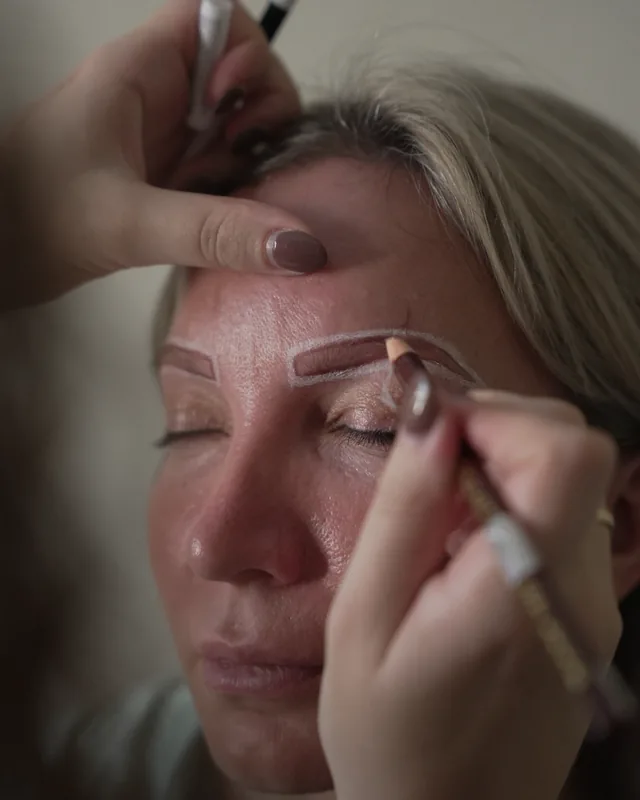 Kristina zeichnet die Brauenform mit Stift vor